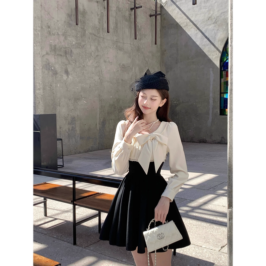 Black dress with a fitted waist, short skirt, and long sleeves  A42